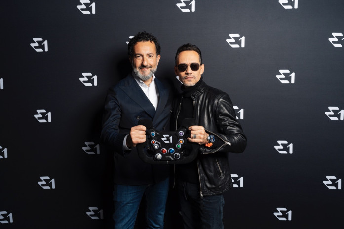 E1 CEO Rodi Basso and Marc Anthony pose with Racebird steering wheel