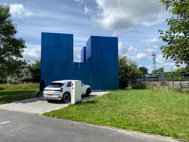 A white truck parked in front of a blue building

Description automatically generated with low confidence